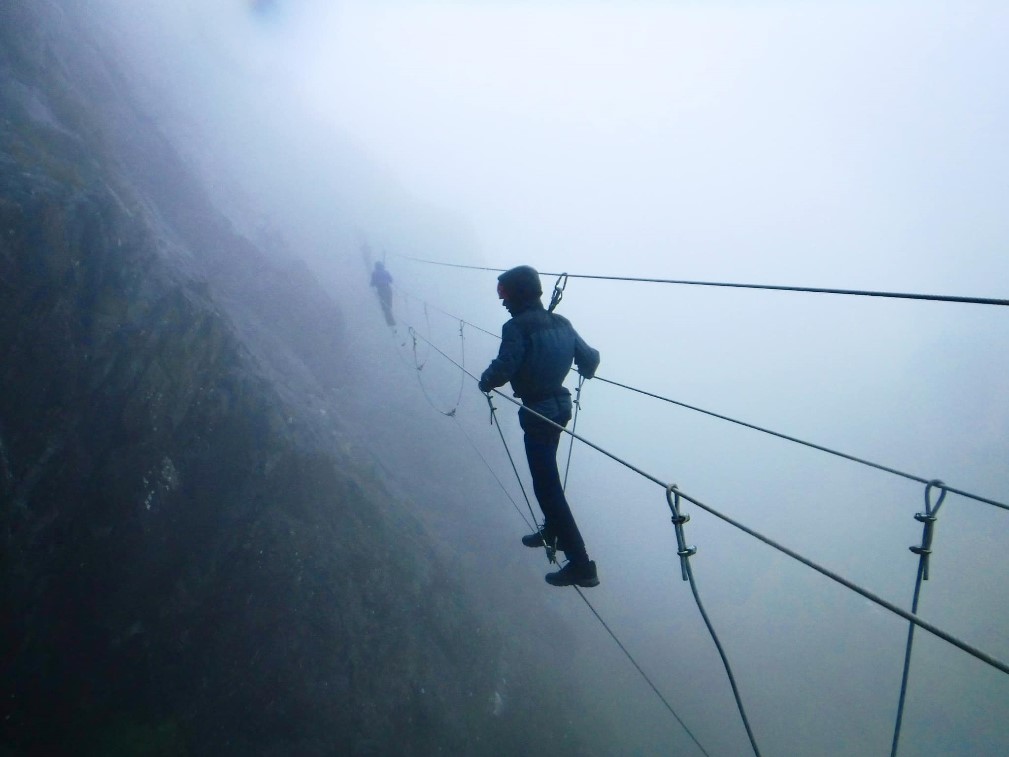 A person on the via ferrata in the mist