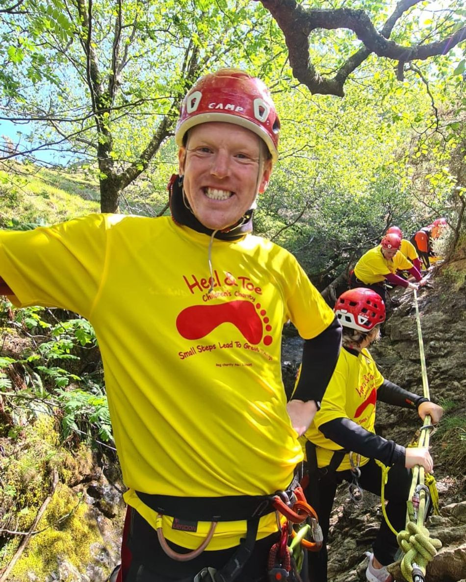 Man ghyll scrambling in a charity t-shirt