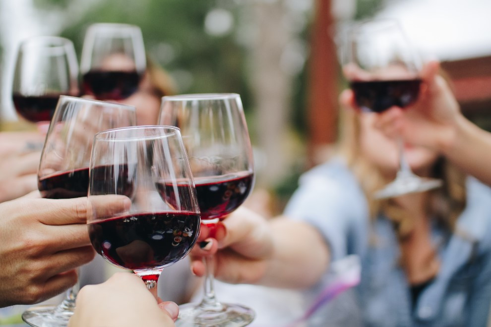 Group of people clinking grasses of red wine