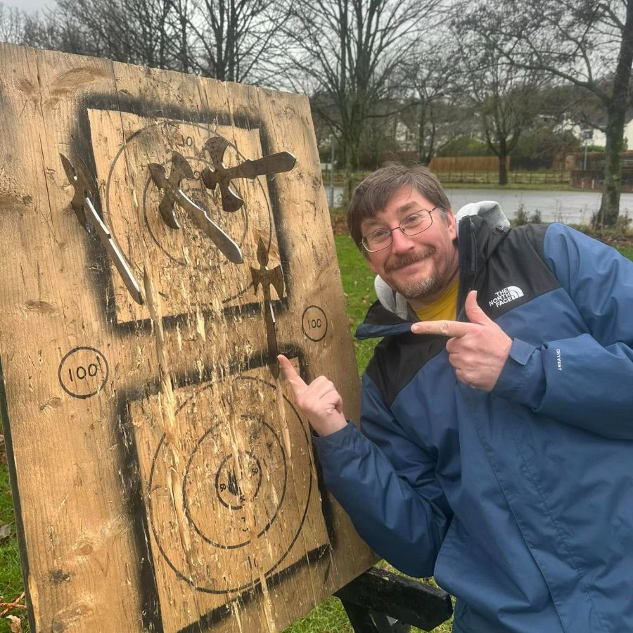 Man pointing at axes in a target