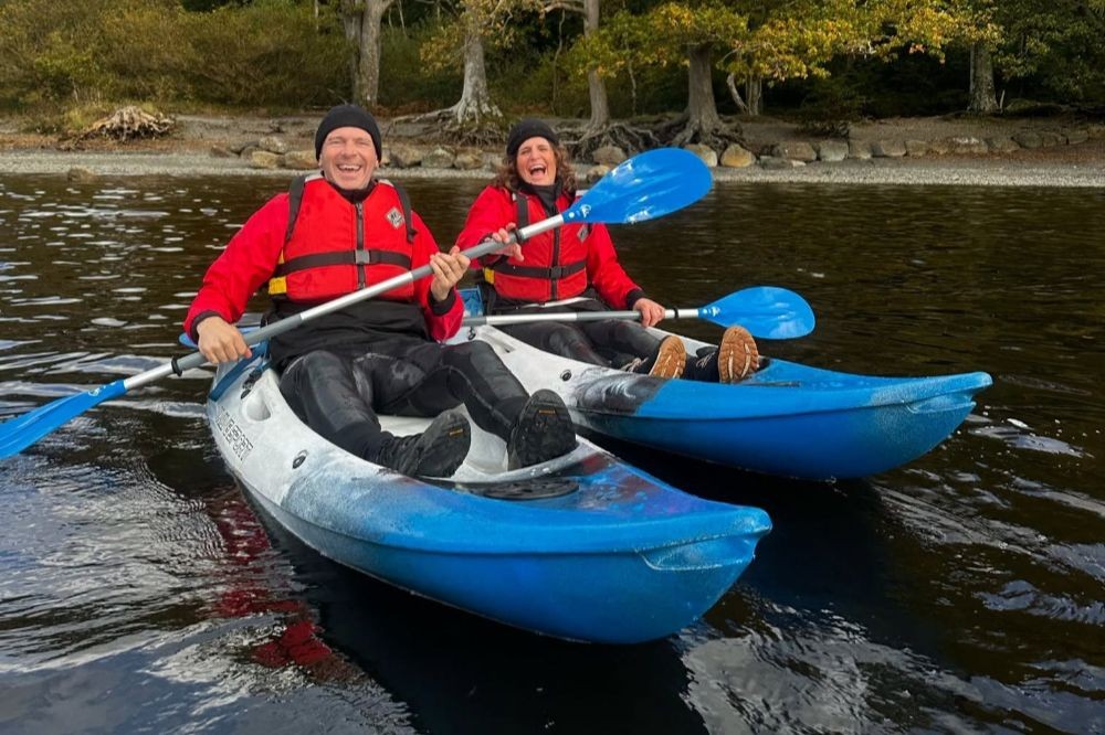 Couple laughing on kayaks on Derwentwat